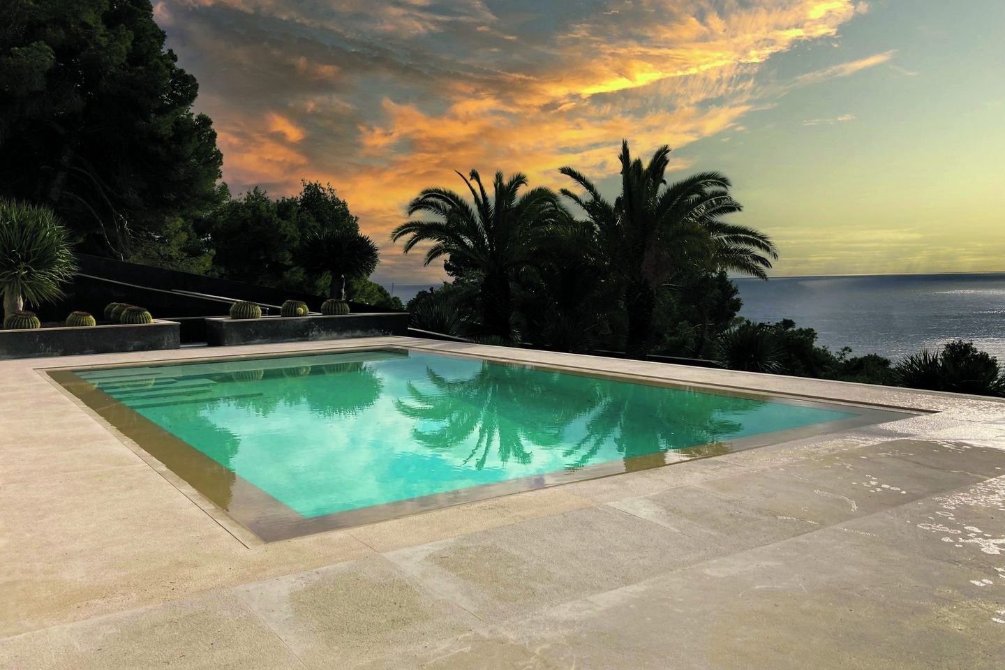 Pool bei Sonnenuntergang mit Blick aufs Meer