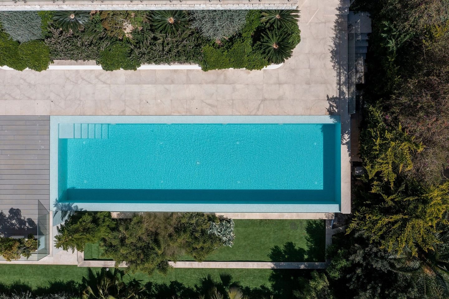 Luftaufnahme eines schmalen Pools in einem Garten mit Hecken