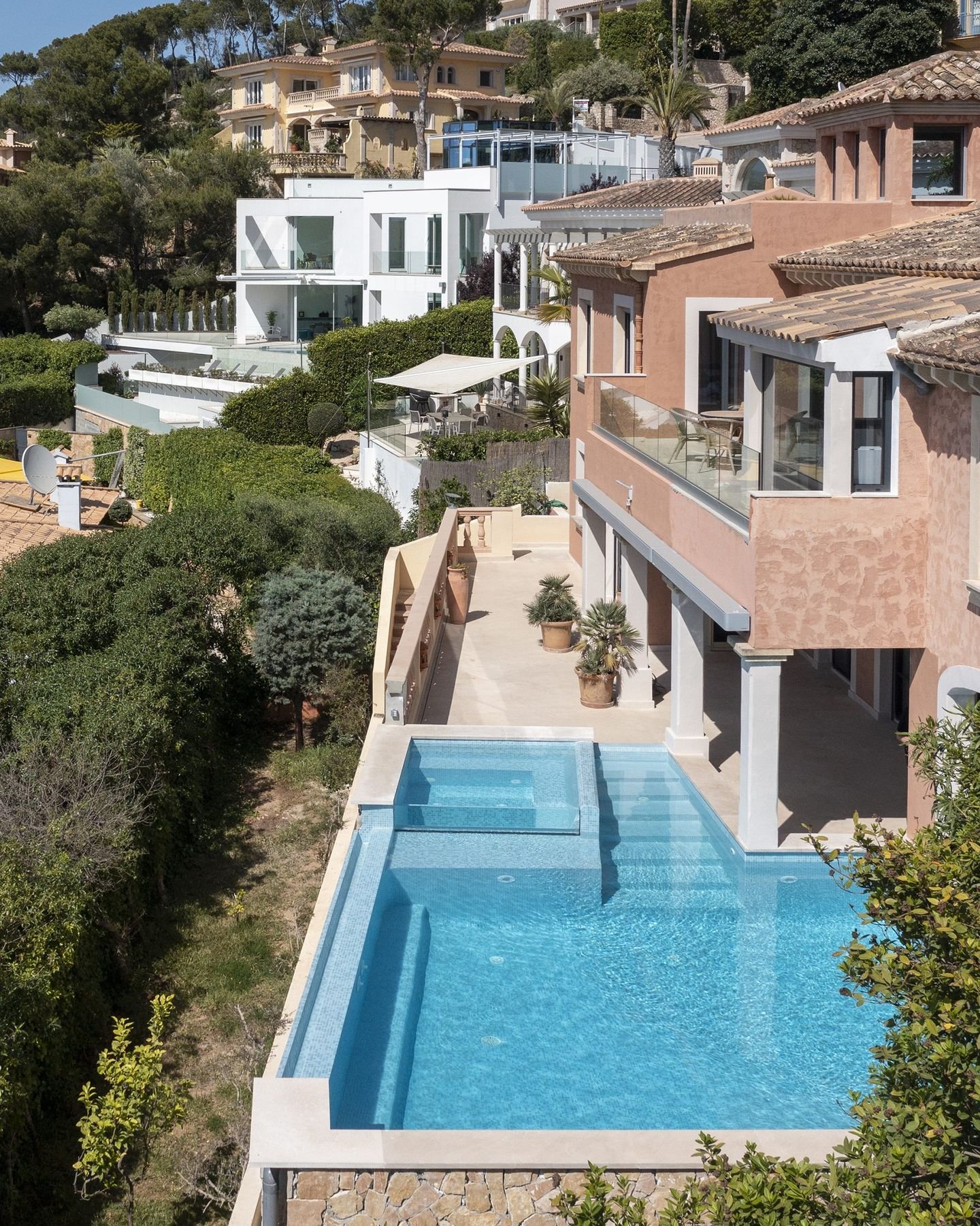 Pool mit Überlaufkante an einem Hang über einer Bucht